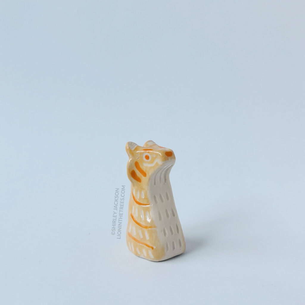 Right side view of the small yellow/orange sgraffito tiger totem.