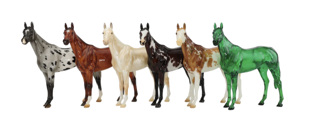 The full lineup of the 6 glossy horses for this year's Surprise model. They were done on the Winx mold. The following colours done in glossy are: Blue Varnish Semi-Leopard Appaloosa, Wild Bay with Gulastra Plume, Cremello, Dark Bay Overo, Chestnut Sabino, and a green clearware designed as a nod to BreyerFest's 35th Anniversary as the emerald is its traditional gemstone.