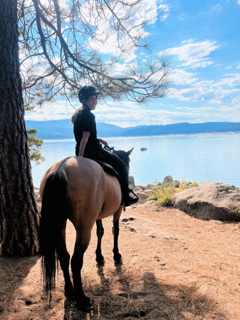 Photo of Dusty and I facing the lake. I'm turned around smiling at the camera.