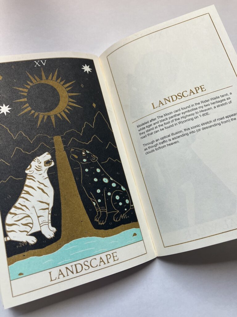 Photo of a spread found in the Wild West Heart zine. This features The Landscape tarot card that illustrates a white tiger and black panther in a setting that mimics The Moon tarot card. The opposite page gives the reader the context behind the illustration for the specific prompt.