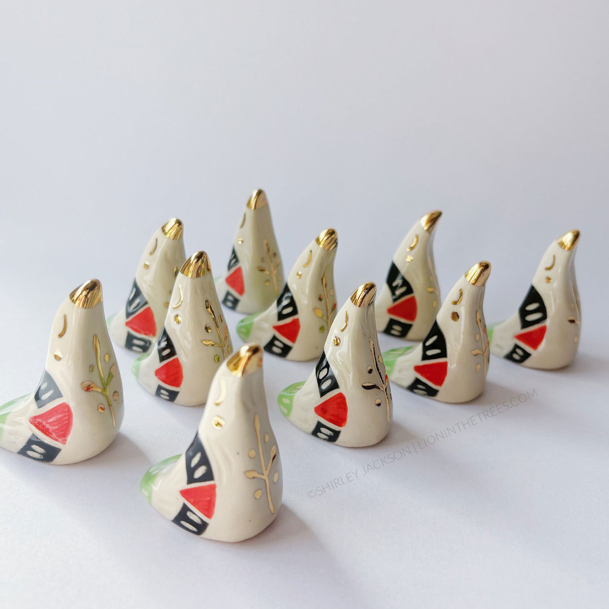 Dove totems done with black, red, and green underglazes that mimic the Palestinian flag; finished with clear glaze and gold overglaze details such as an olive tree branch motif.