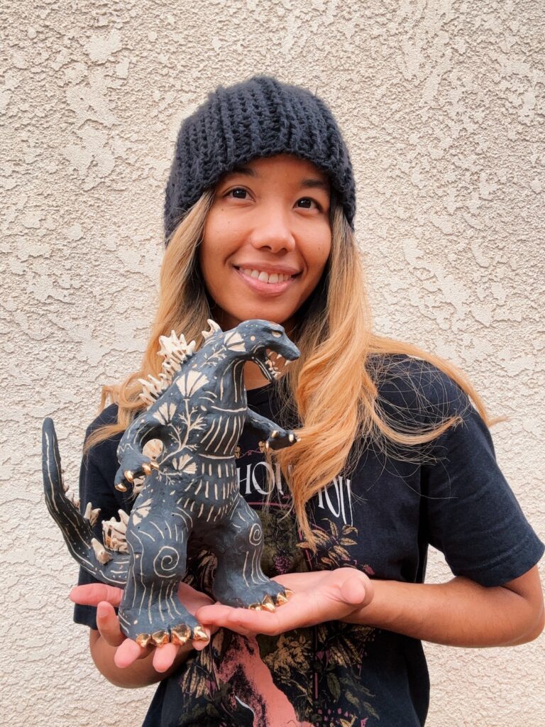 Me, showing off my beautiful smile thanks to two and a half year's of braces, holding Godzilla balanced in my hands.