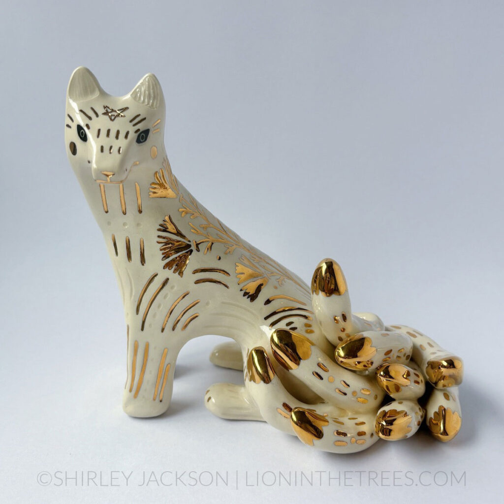 White sgraffito Kumiho with gold overglaze details all over it's body.