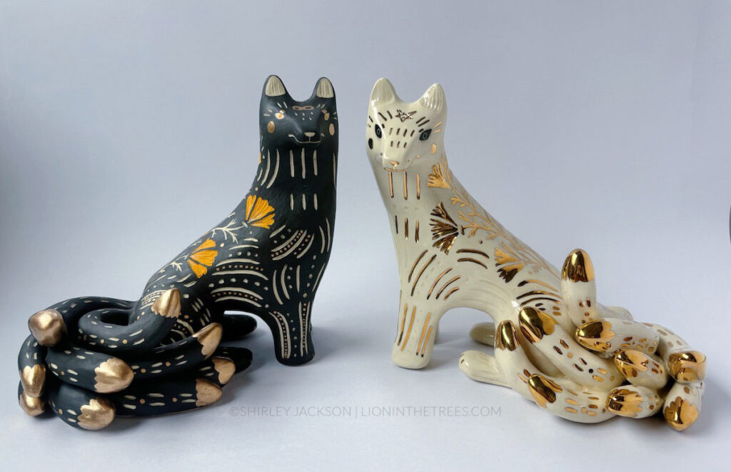 The black and white sgraffito Kumiho sculptures next to one another.