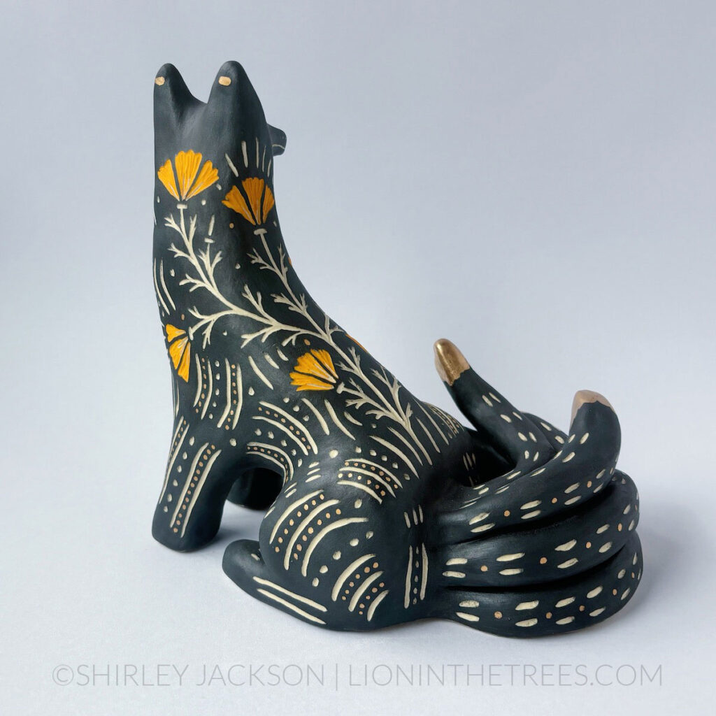 Black and orange sgraffito kumiho with gold luster details. The back of the piece also shows orange underglaze sgraffito California Poppies.