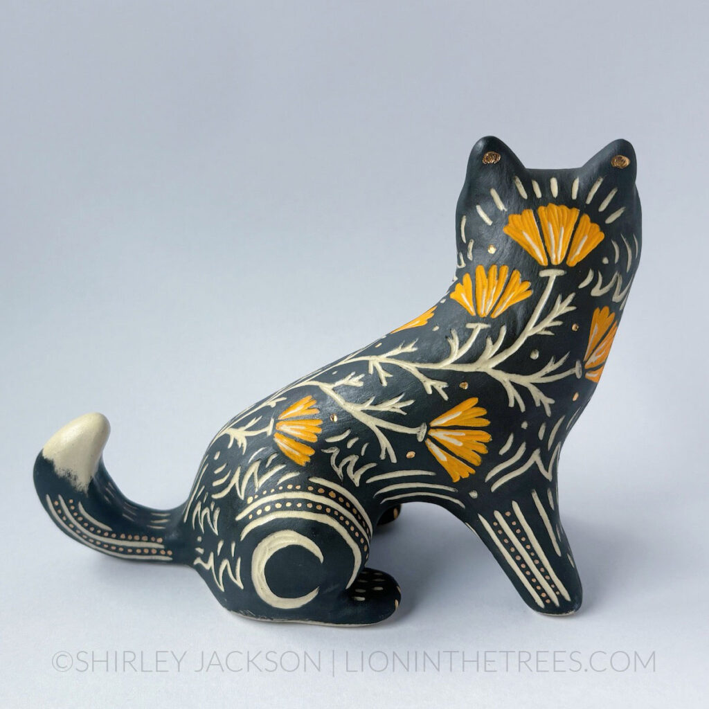 Black underglaze sgraffito wolf with California Poppies and crescent moon details all over it's body.