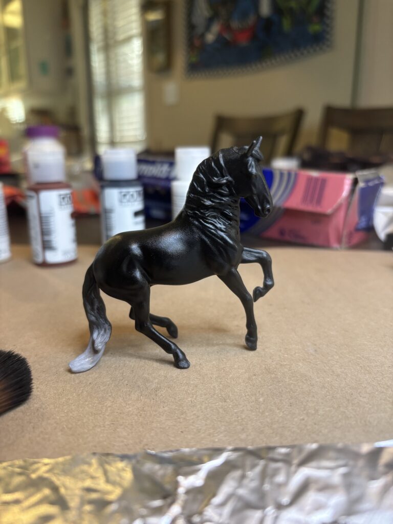 The horse painted with a darker layer of grey/black