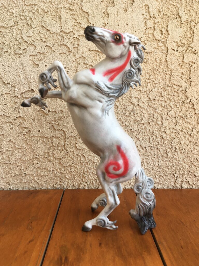 A classic scale model horse done on a mold that is rearing up painted to resemble Kazegami, a red and white horse from the Okami series.