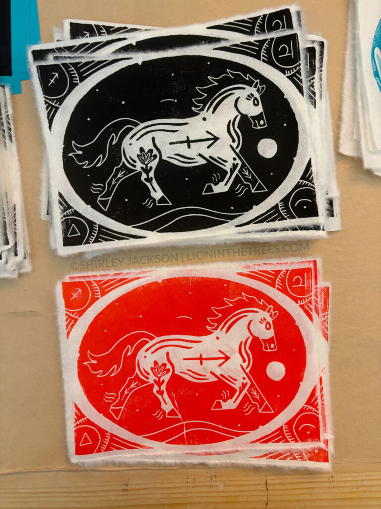 Photo showing two block prints of my mustang Sagittarius design. The top print was done with black ink and the print on the bottom was done with a red ink.