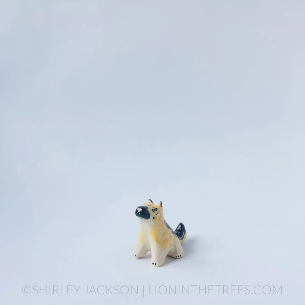 Small ceramic german shepherd dog with a black/tan coat colour