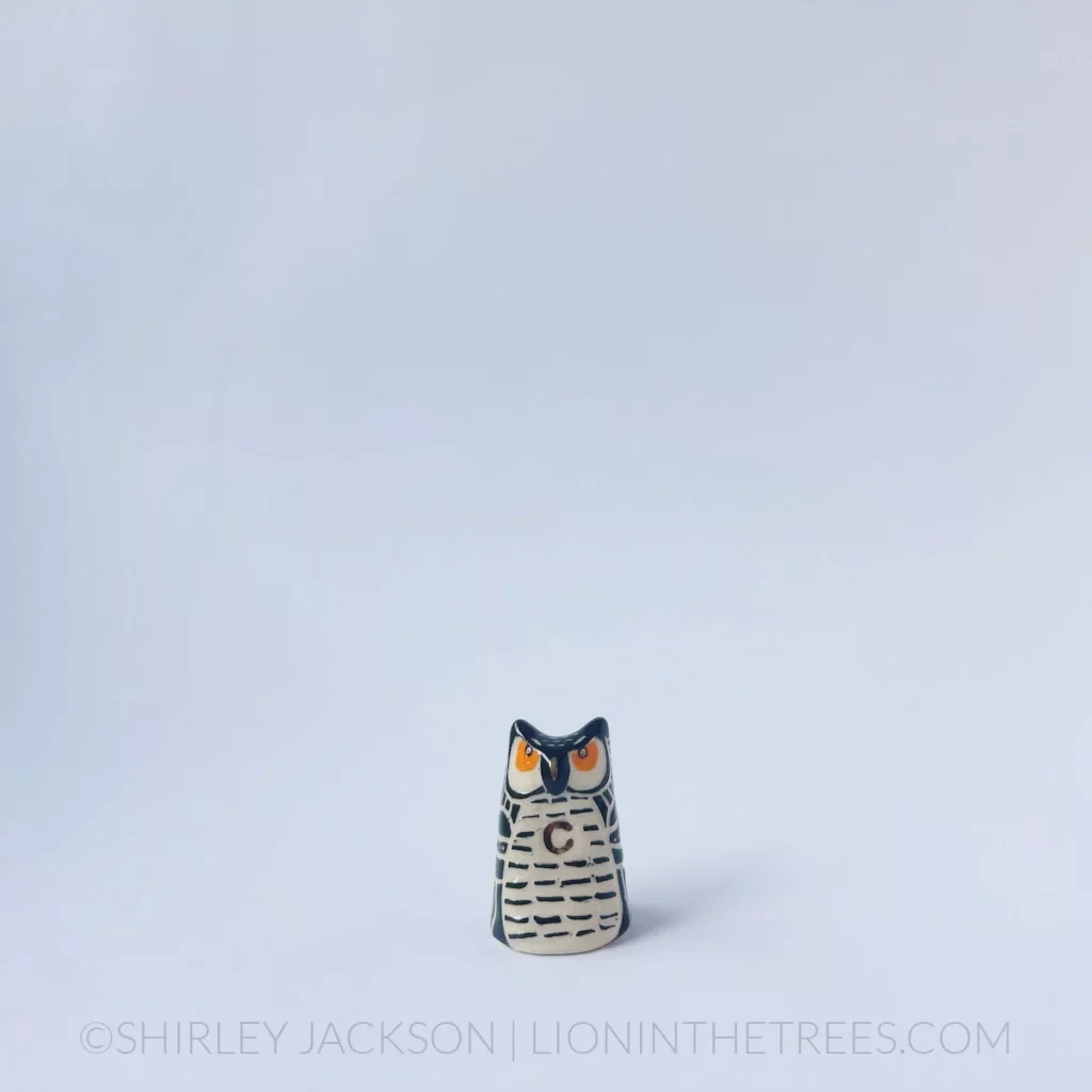 Small ceramic owl with a crescent moon in the center of it's chest