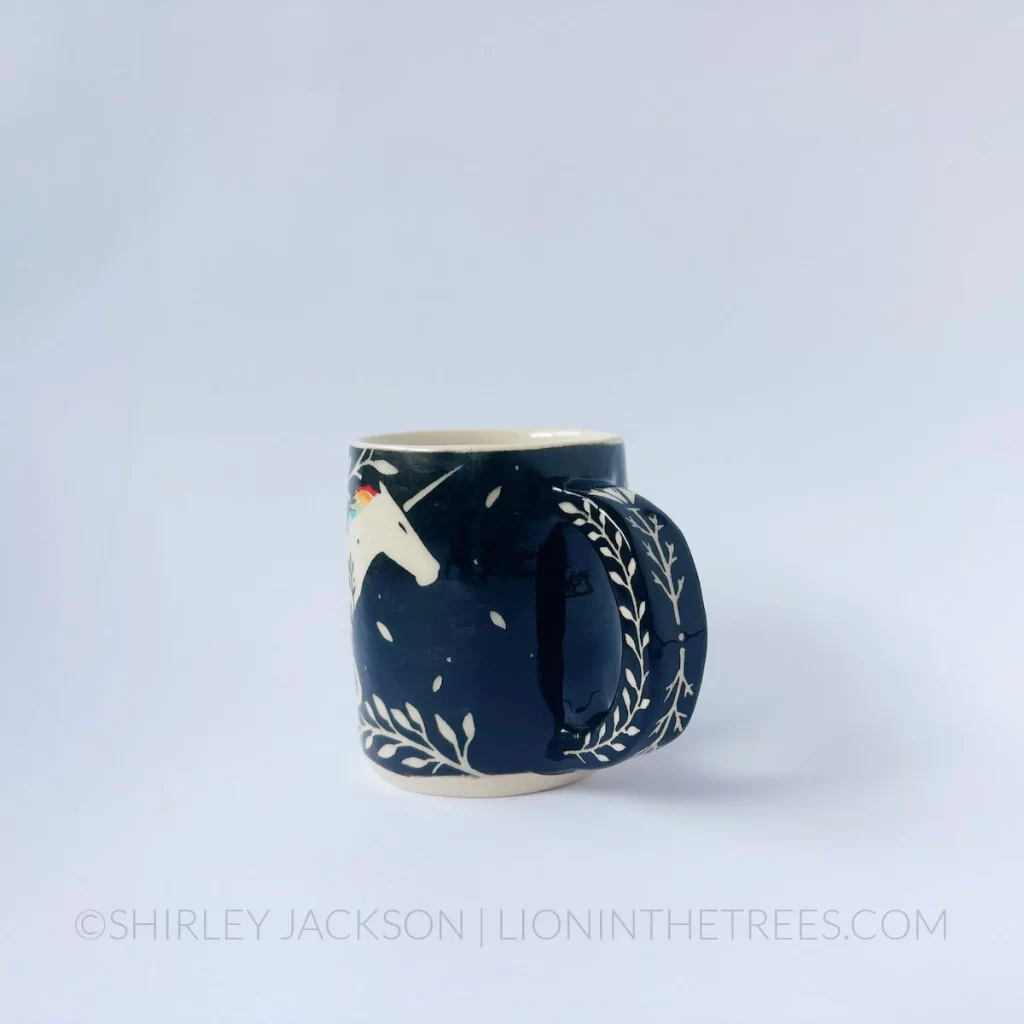 Black and cream sgraffito mug featuring my Rainbow Unicorn motif and floral elements
