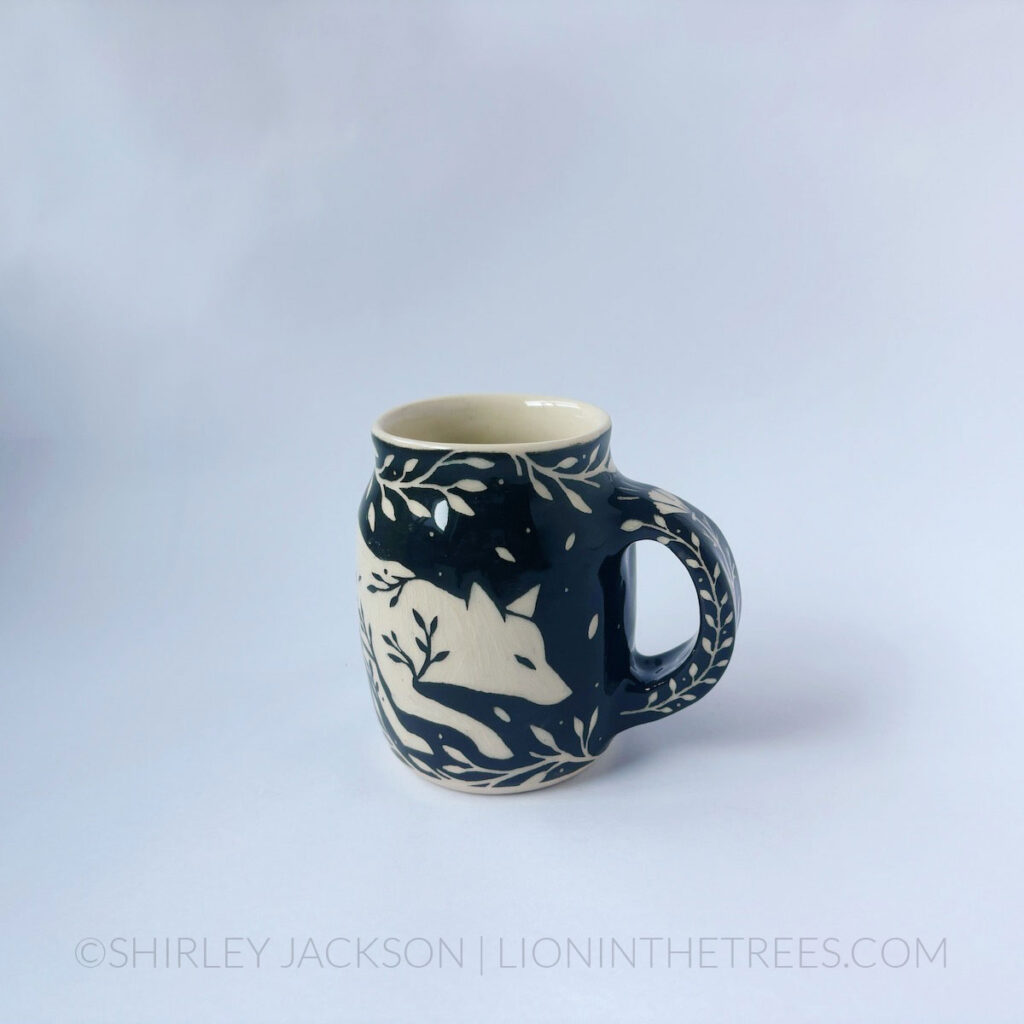 Black and cream sgraffito mug featuring my Running Fox motif and floral elements