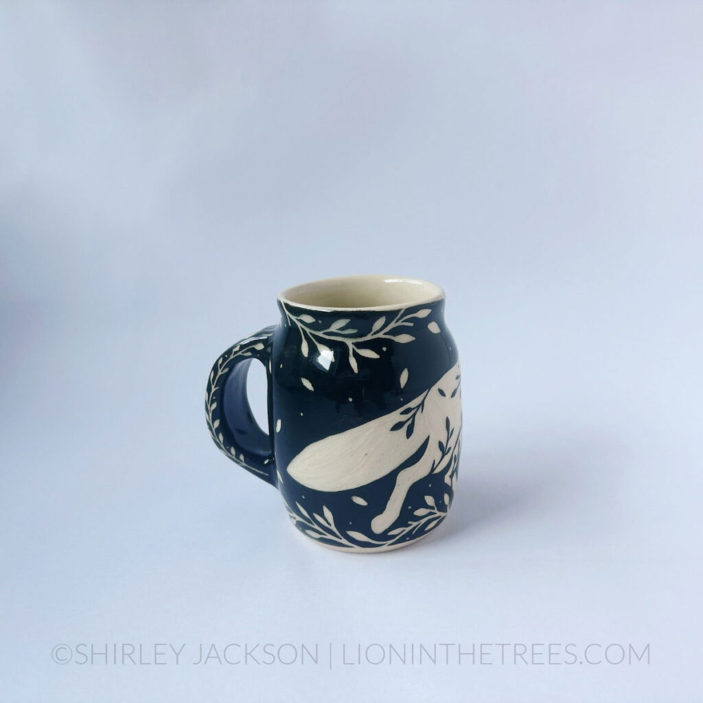 Black and cream sgraffito mug featuring my Running Fox motif and floral elements