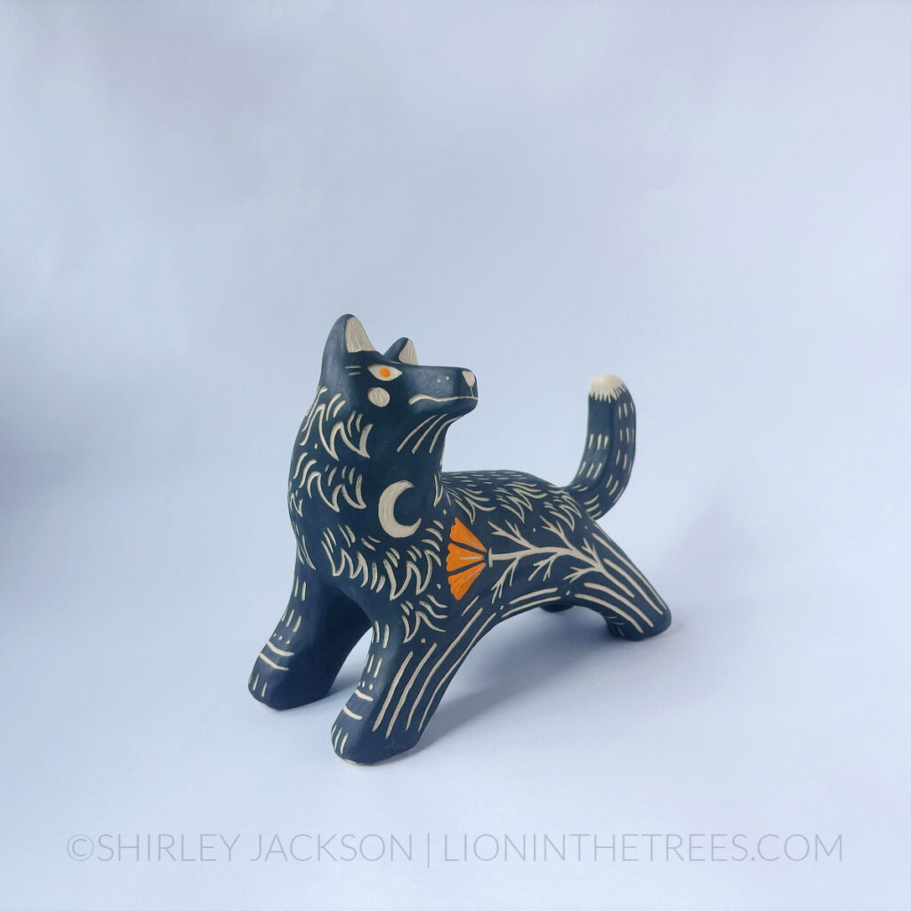 Wolf totem done with various underglazes in a pose that looks as though the wolf is leaping.