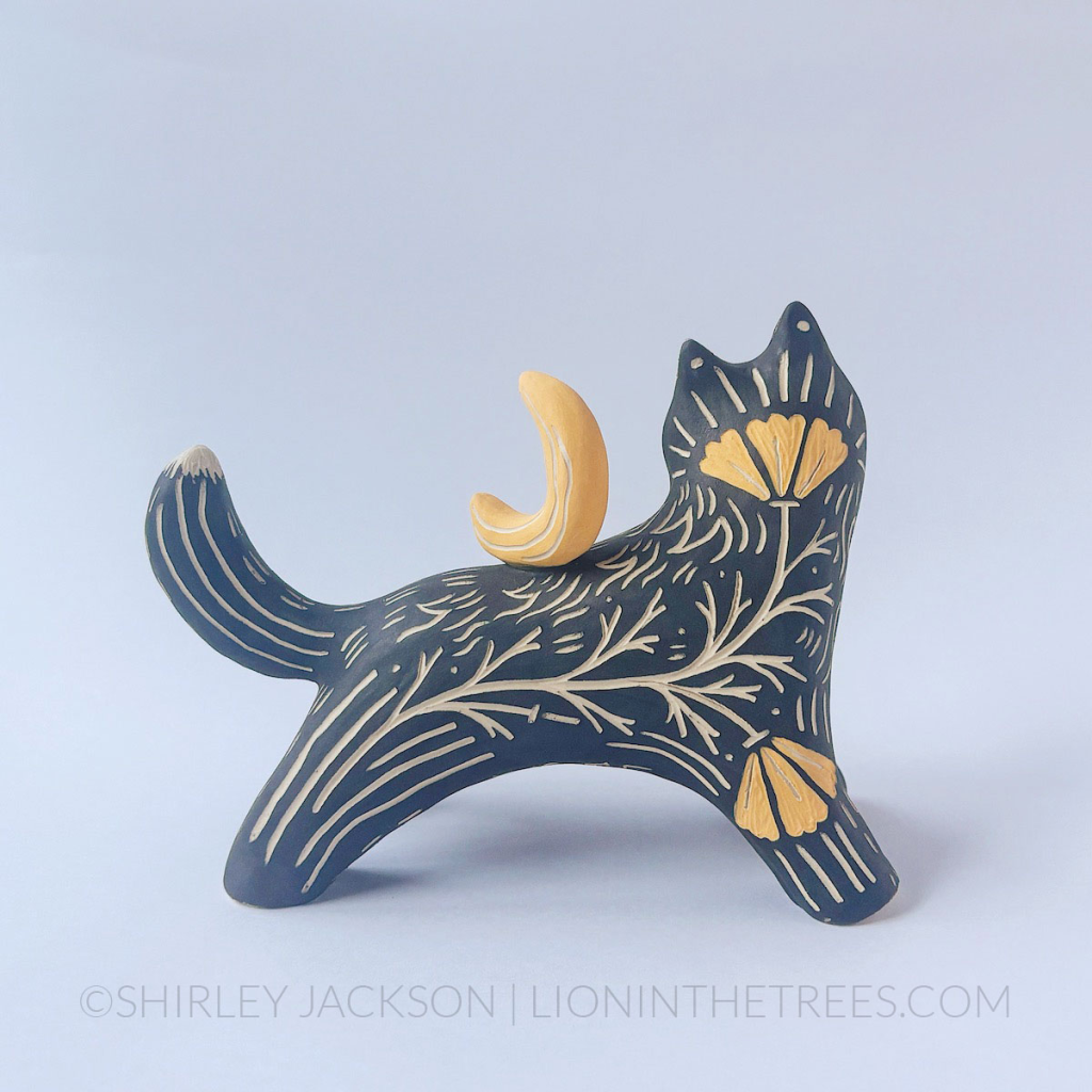 back of the sculpture that shows another sgraffito California Poppy motif crawling up the wolf's back.