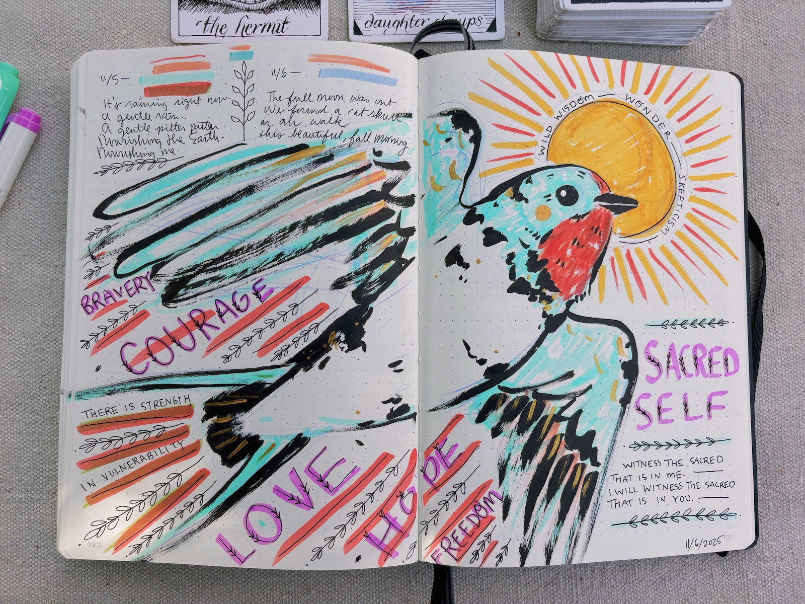 A sketch spanning across a spread inside a sketchbook. It features a Barn Swallow and a variety of words and phrases like love, bravery, courage, sacred self done in a variety of markers and pen.