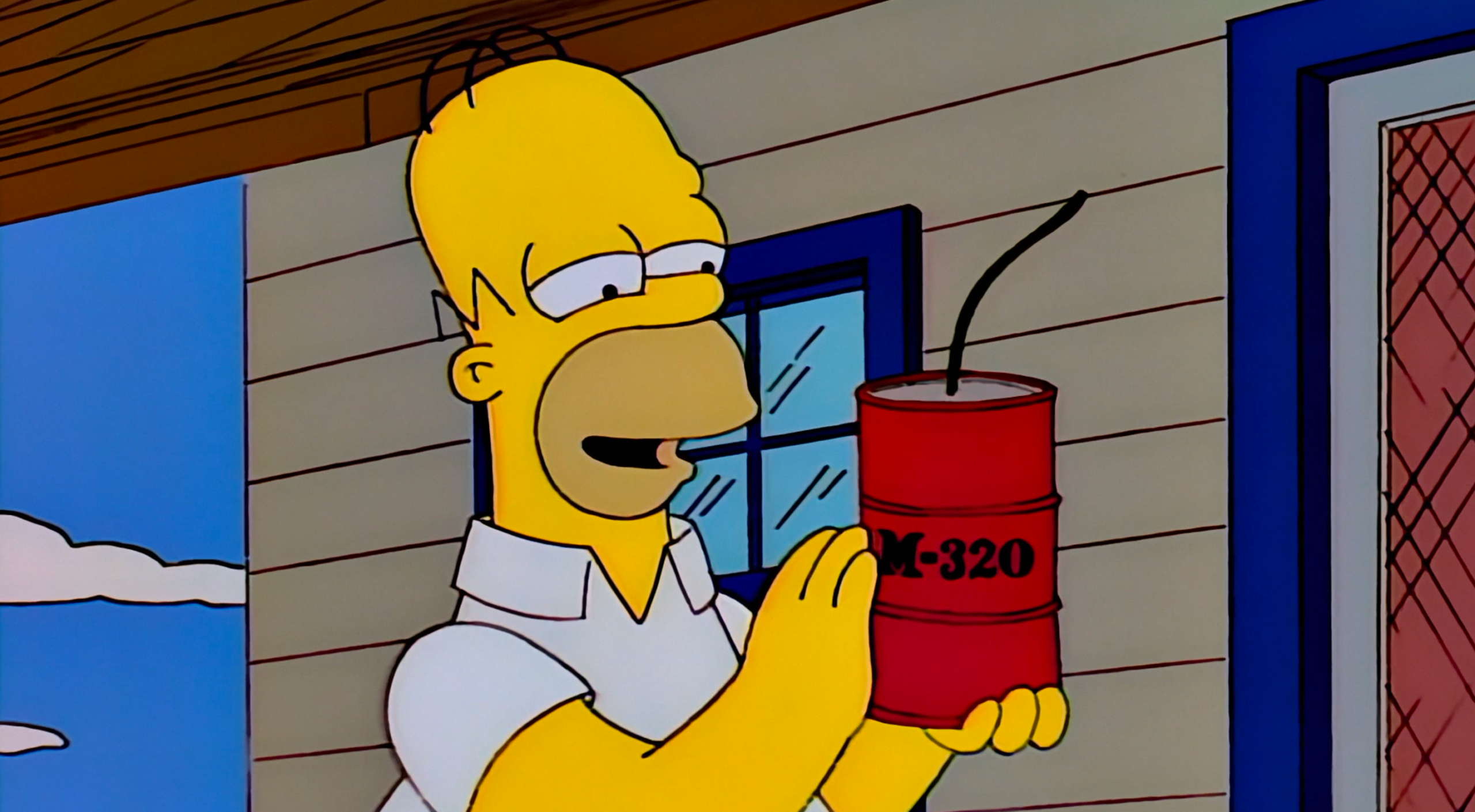 A screen shot of Homer Simpson holding a M-320 firework. It's basically a red drum (container) that can fit in the palm of his hand. And he's kind of caressing it with a smile on his face here in the still.
