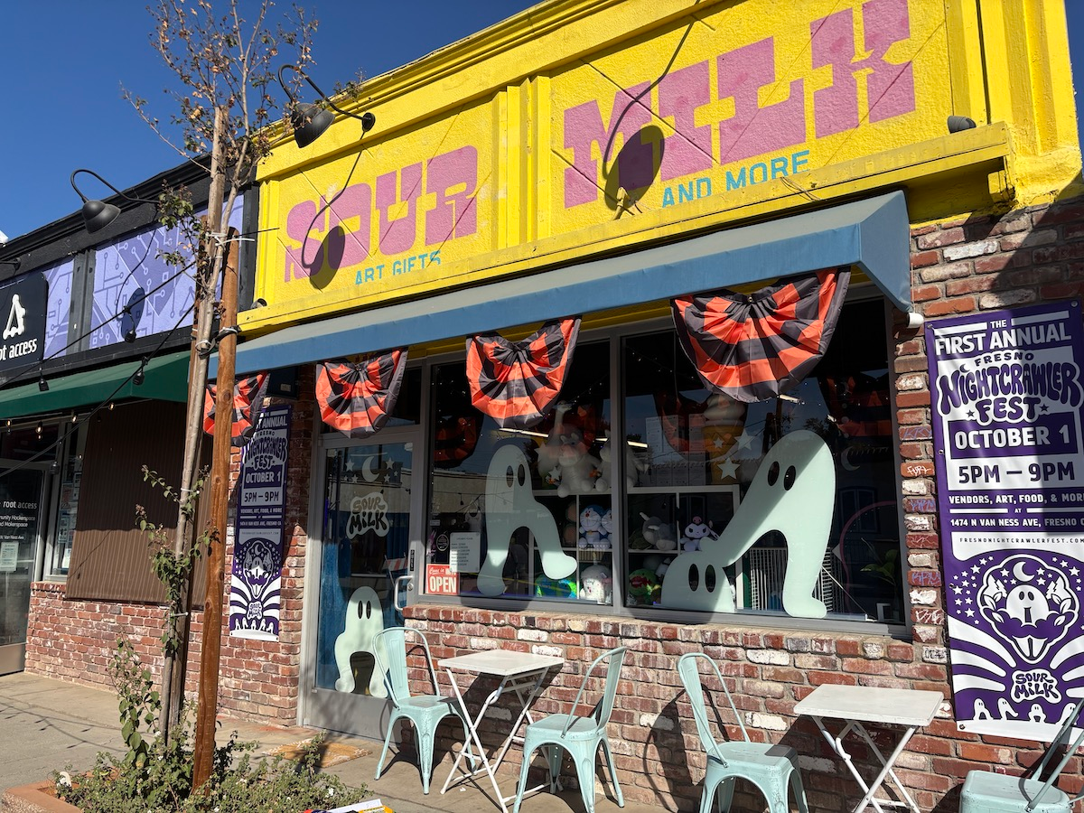 The front of Sour Milk shop which shows a variety of giant Fresno Nightcrawler window clings, as well as the festival banner on either side of the building.