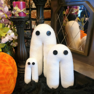 Crocheted Fresno Nightcrawlers with button eyes posed in a romantic, gothic setting